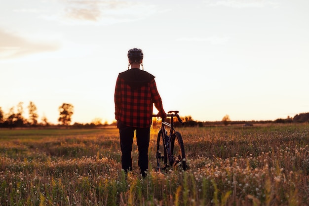 Silhouette d'un cycliste et de son vélo sur fond de ciel coucher de soleil. Concept de mode de vie sain et sportif.