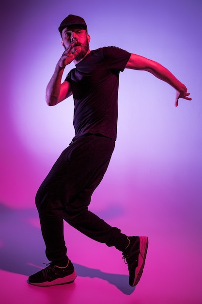 Photo la silhouette d'un danseur de break hip hop masculin dansant sur fond coloré