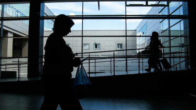 Silhouette de deux femmes marchant sur le fond de la fenêtre panoramique