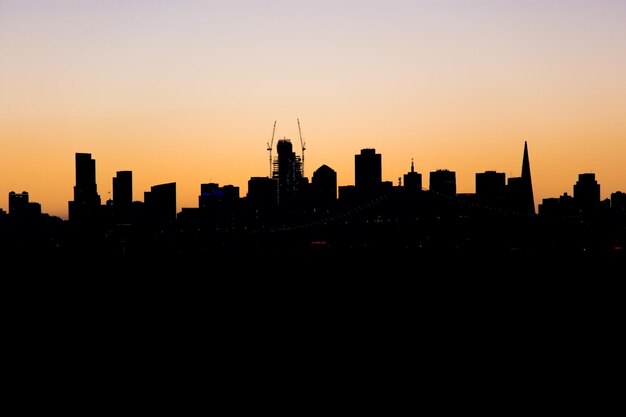 Photo silhouette du paysage urbain contre le ciel au coucher du soleil