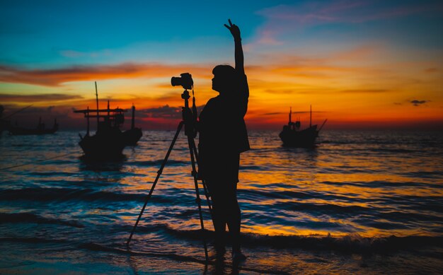 Silhouette du photographe avec l'heure du coucher du soleil.