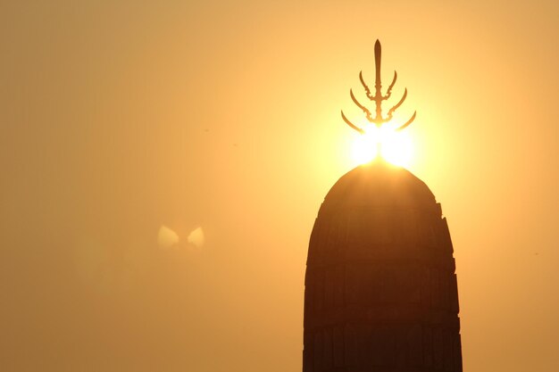 Photo la silhouette du temple contre le ciel orange