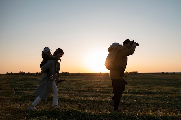 Photo silhouette familiale complète s'amusant au coucher du soleil