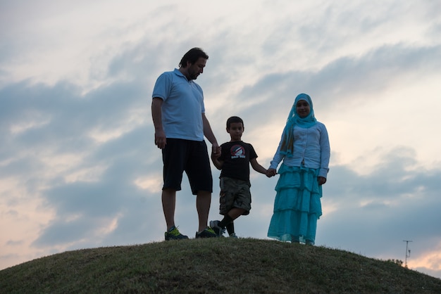 silhouette de famille heureuse, s&#39;amusant sur la falaise