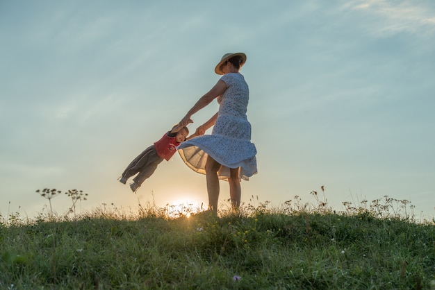 silhouette de famille heureuse, s&#39;amusant sur la falaise