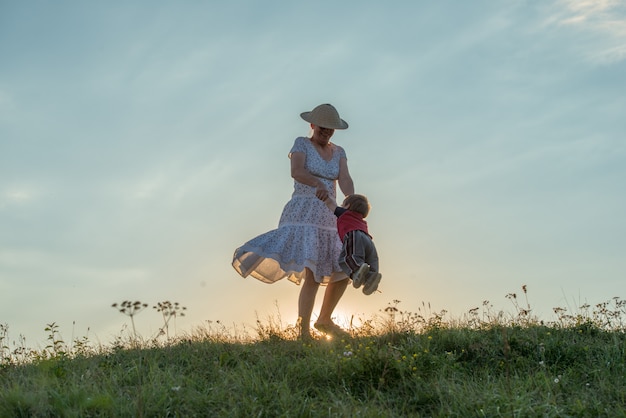 silhouette de famille heureuse, s&#39;amusant sur la falaise