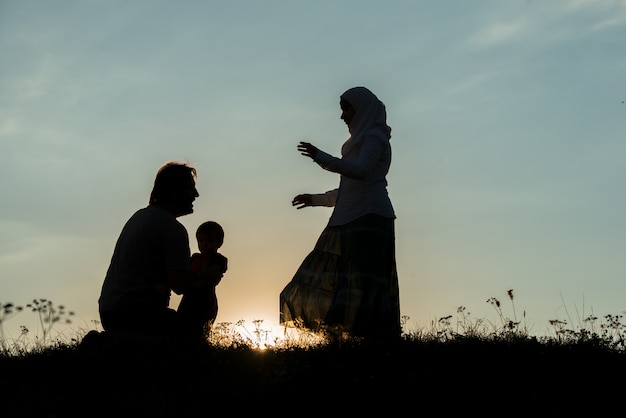 silhouette de famille heureuse, s&#39;amusant sur la falaise