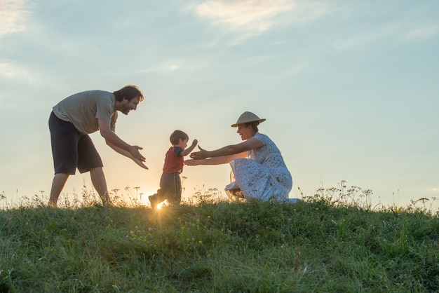 silhouette de famille heureuse, s&#39;amusant sur la falaise