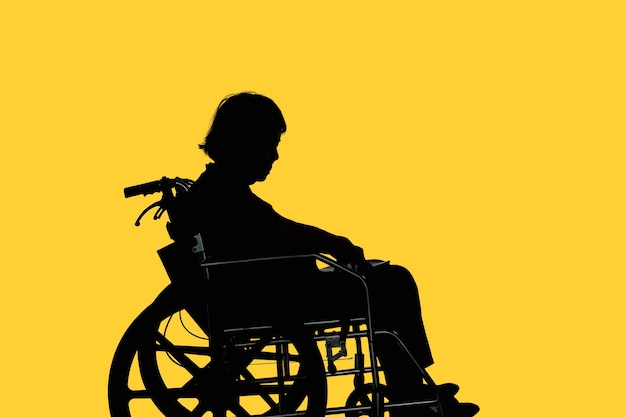 Photo silhouette de femme âgée handicapée et découragée assise dans son fauteuil roulant