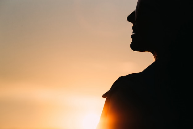 Silhouette de la femme au coucher du soleil