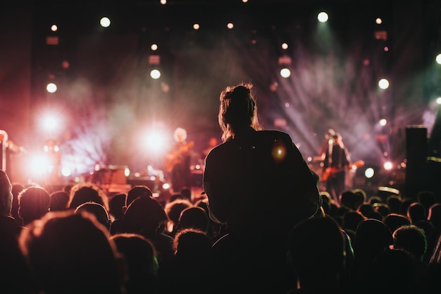 Photo silhouette d'une femme aux mains levées sur un concert