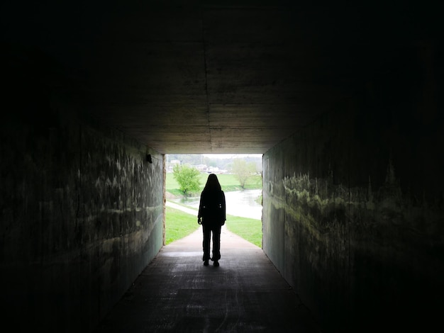 Photo silhouette d'une femme dans un tunnel