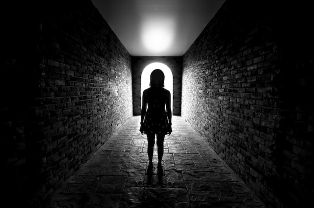 Photo la silhouette d'une femme debout dans un tunnel