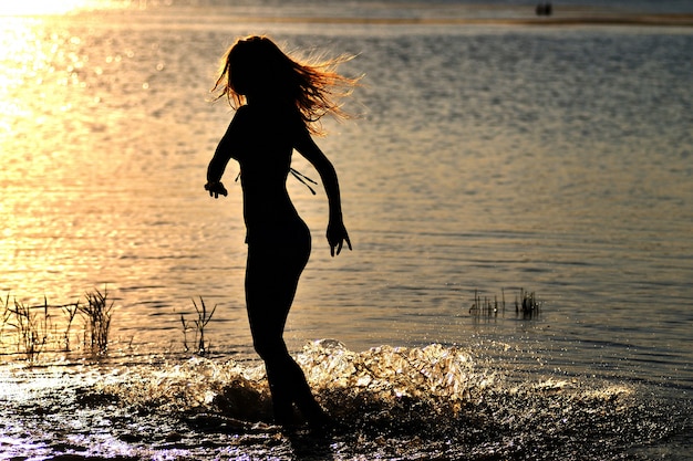 Silhouette, femme, debout, eau, confection, eau, cercles, cheveux