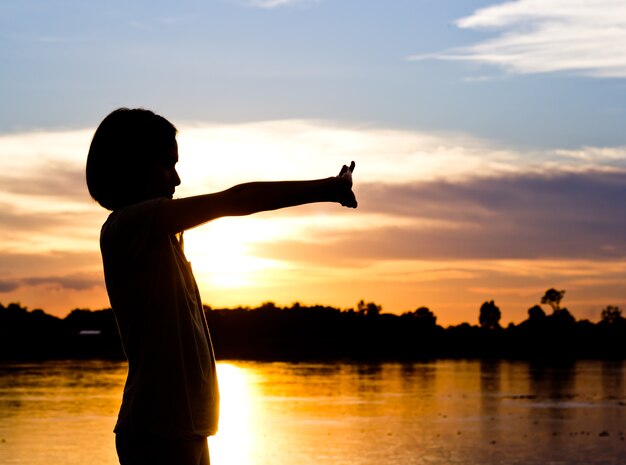 Silhouette de femme exerçant sur le magnifique fond de coucher de soleil.