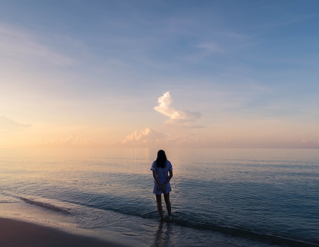 Silhouette de femme marchant sur le fond de la plage avec filtre vintage