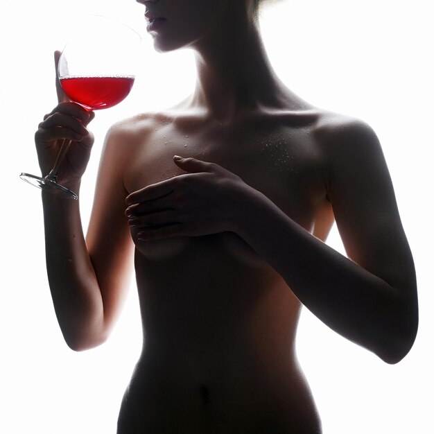 Silhouette de femme nue avec du vin rouge