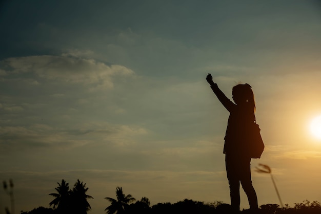 Silhouette de femme pointant avec le doigt dans le ciel