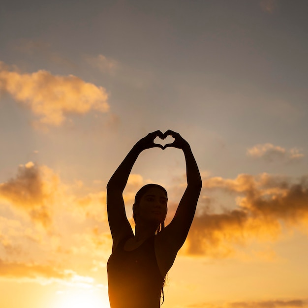 Silhouette de femme posant au bord de la plage