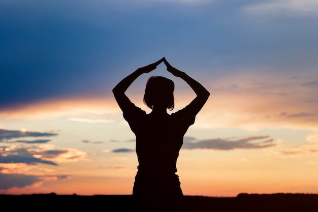 Silhouette de femme posant au coucher du soleil