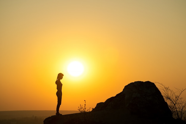 Silhouette d'une femme randonneur debout seul près de grosse pierre