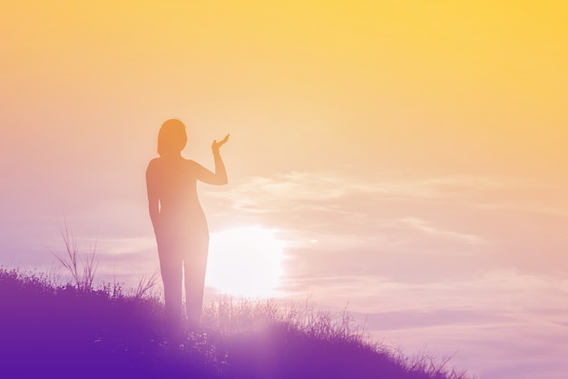 Silhouette de femme si heureuse au coucher du soleil