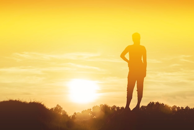 Silhouette de femme si heureuse au coucher du soleil