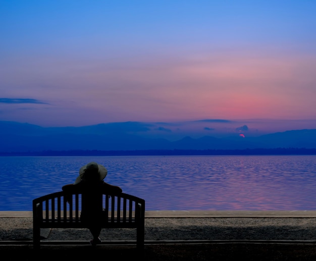 Silhouette femmes assises seules. Triste et solitaire. Mer et plage en été.