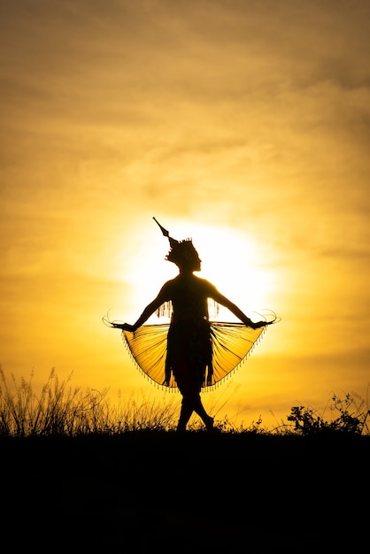 Photo silhouette femmes manohra dansent avec coucher de soleil dans le sud de la thaïlande.