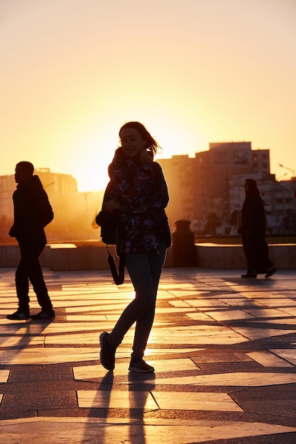 Silhouette d'une fille au coucher du soleil en hiver à Casablanca Maroc. Le soleil se couche derrière la fille. Les rayons du soleil sont jaune doré. Maroc, Casablanca, 18 décembre 2017