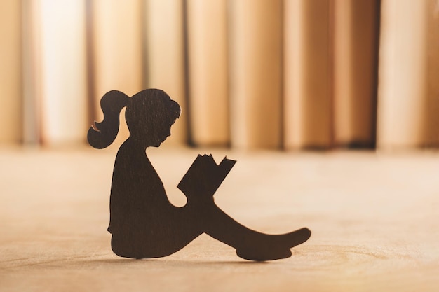 Silhouette d'une fille découpée sur le fond des livres