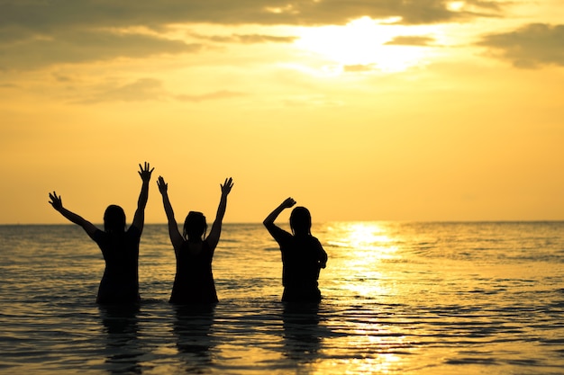 silhouette fille heureuse sur la mer et le ciel coucher de soleil sur la plage de la Thaïlande