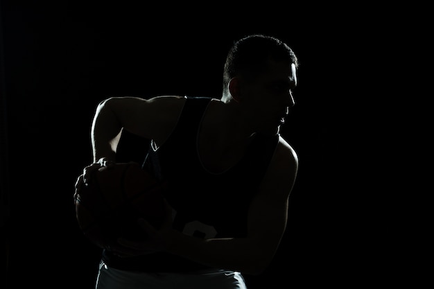 Photo silhouette de la formation des joueurs de basket-ball avec un fond noir