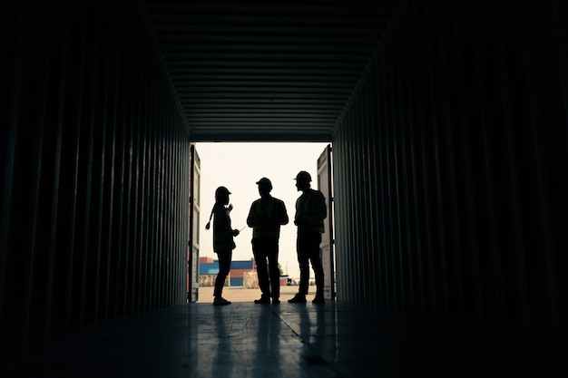 Silhouette Groupe d'employés debout et vérifiant la boîte des conteneurs du cargo pour l'exportation et l'importation