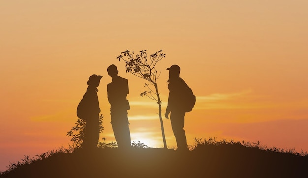 Silhouette d'un groupe de personnes debout sur fond naturel de montagne