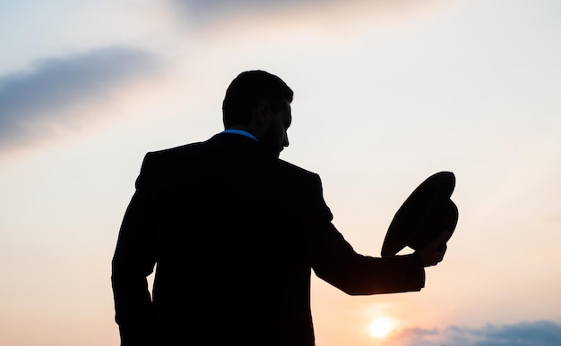 Silhouette d'homme d'affaires avec chapeau contre la mode du ciel coucher de soleil