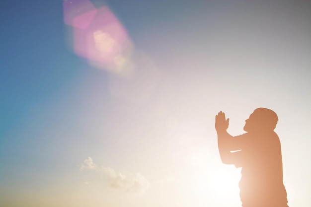 Silhouette d'un homme contre un ciel clair au coucher du soleil
