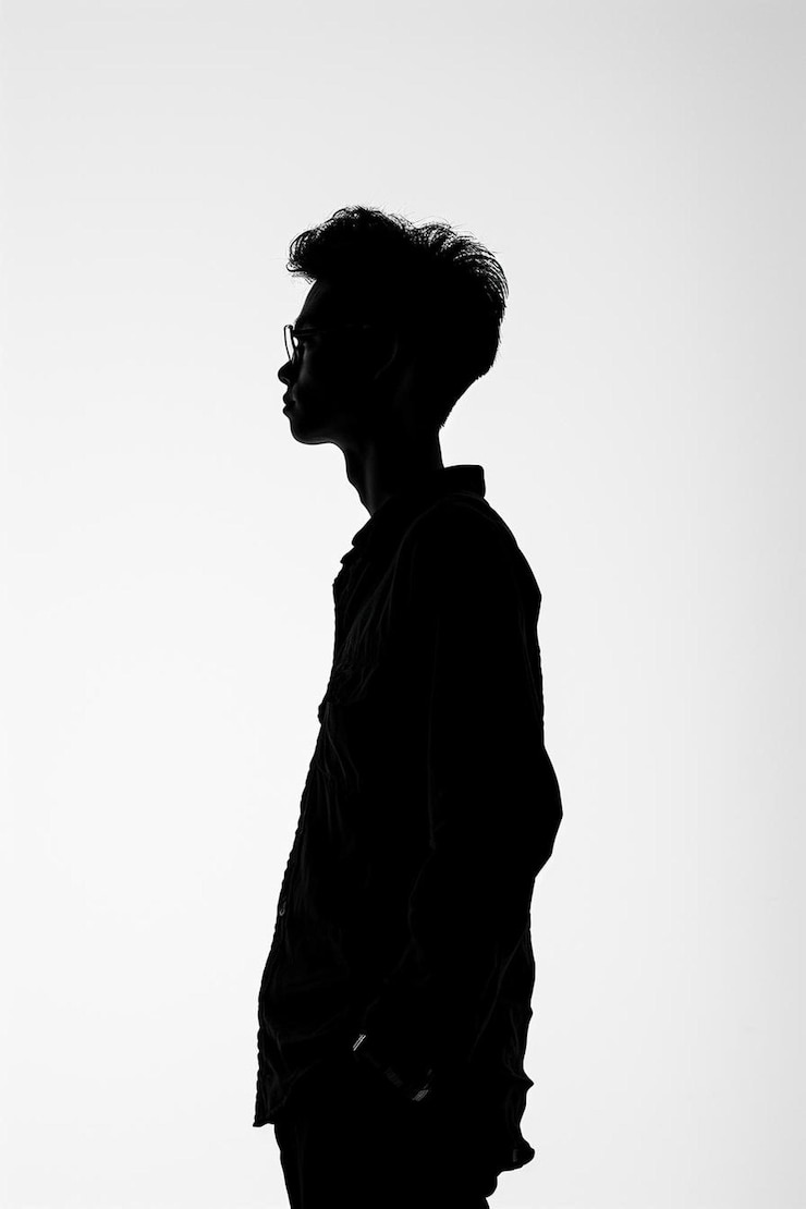 Photo une silhouette d'un homme dans une veste et des lunettes