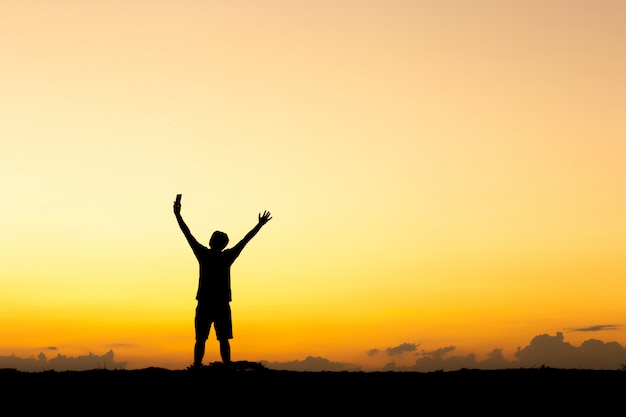 Silhouette d'homme debout au coucher du soleil