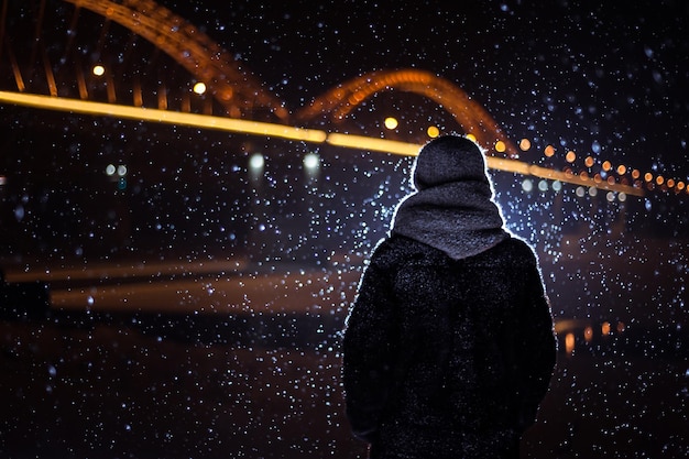 Silhouette d'un homme sur le fond des chutes de neige en hiver