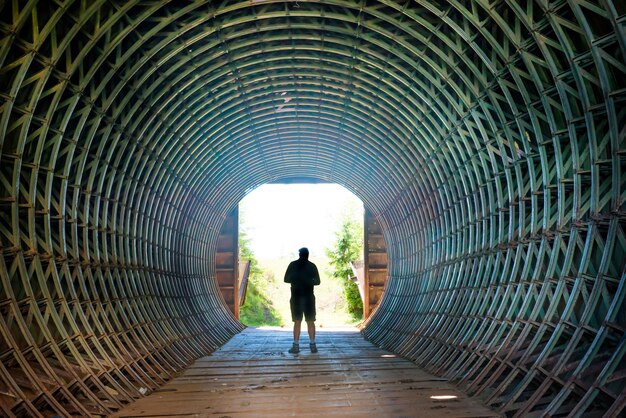 Silhouette d'un homme et lumière au bout du tunnel sombre