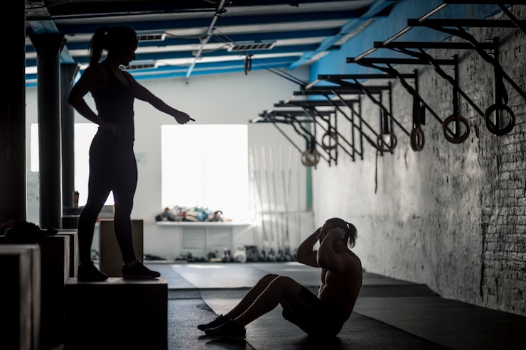 Photo silhouette d'homme musclé exerçant faire de l'exercice assis