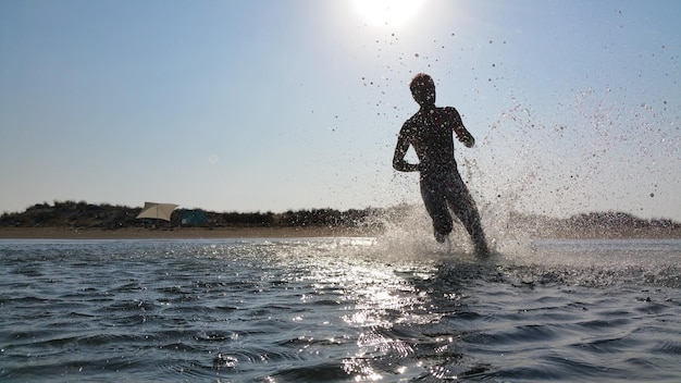 Silhouette d'un homme qui court dans la mer