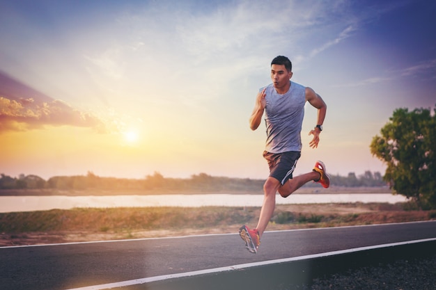 Photo silhouette d'un homme qui court le sprint sur route. fit coureur de fitness masculin pendant l'entraînement en plein air