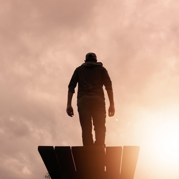 Photo la silhouette d'un homme regardant le beau coucher de soleil en été