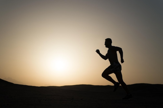 Silhouette ou homme runner guy courir en plein air à ciel clair