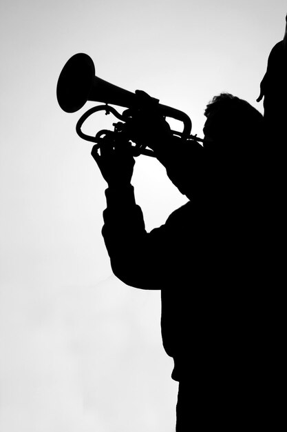 Photo silhouette d'un homme tenant une caméra contre le ciel