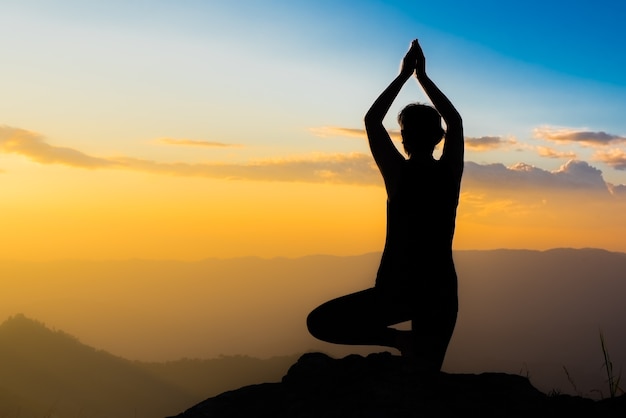 Photo silhouette images de fille prune joue yoga pose sur les hautes montagnes