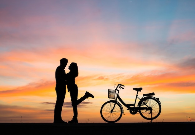 Photo silhouette jeune couple amoureux passe du bon temps ensemble au coucher du soleil