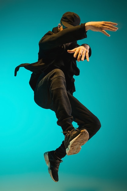 Photo la silhouette d'un jeune danseur de break hip hop masculin dansant sur fond coloré